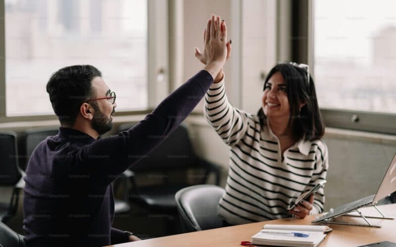 Equipe comercial comemorando um resultado no escritório